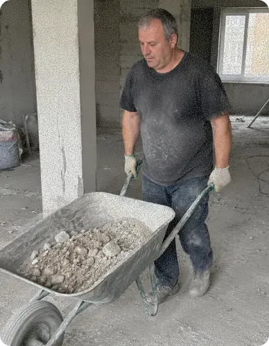 разнорабочий убирает строительный мусор