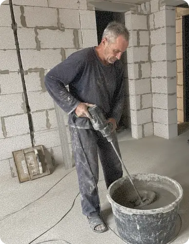 разнорабочий мешает цемент